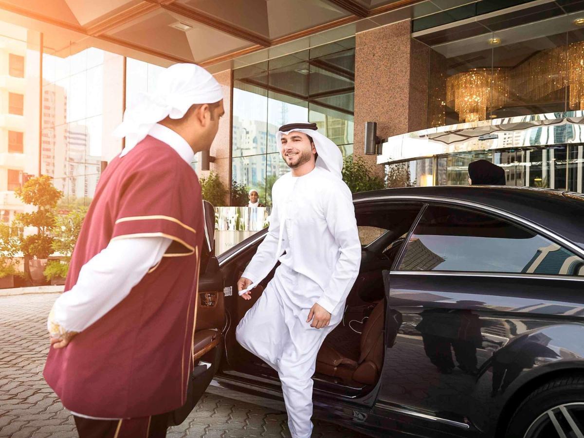 Grand Mercure Majlis Residences Абу Даби Екстериор снимка A guest being helped out of a car